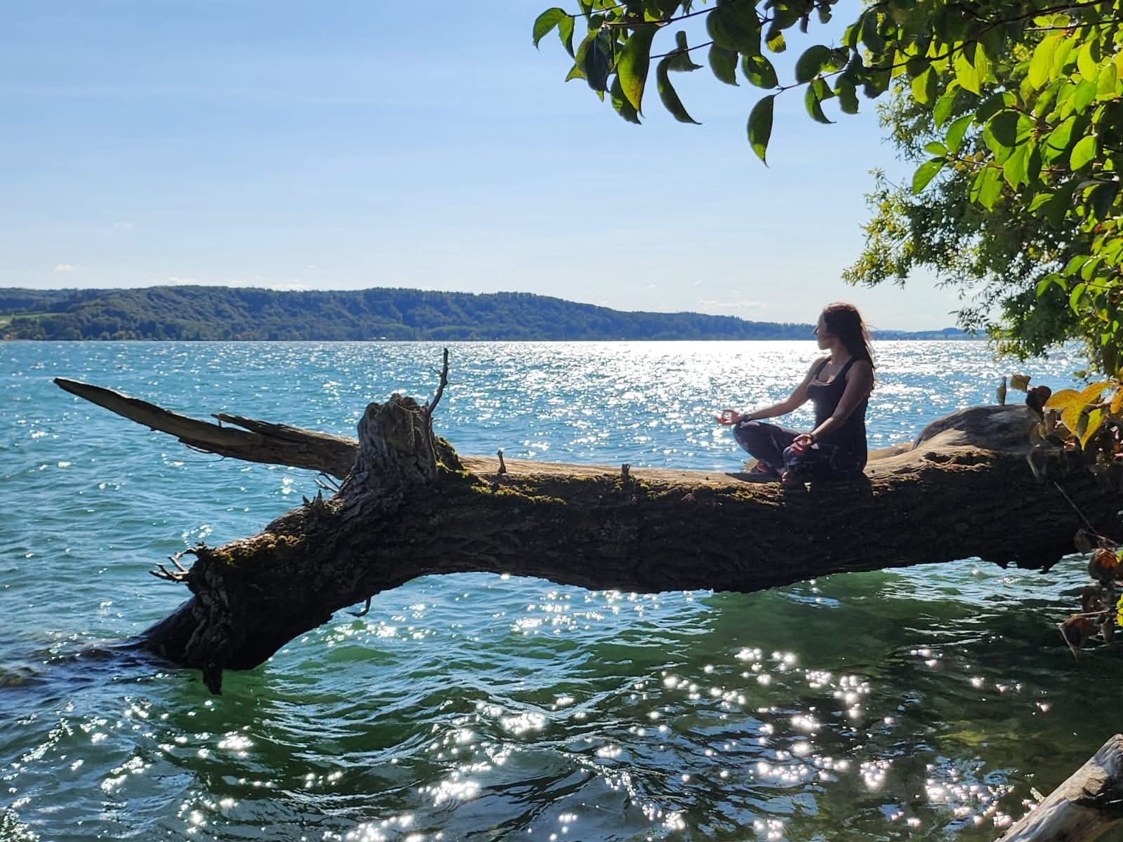 Femmes en posture de yoga assise au bord de l'eau.
